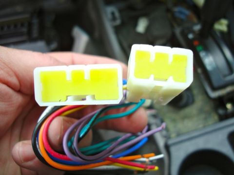 2002 Toyota 4Runner - Close-up of car stereo wiring harness connectors and wires being held.