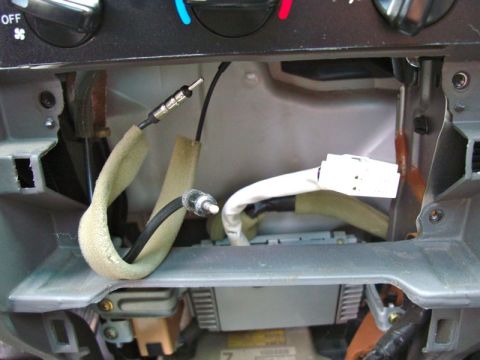 2002 Toyota 4Runner - Close-up view of car interior dashboard wiring and connectors during stereo installation.