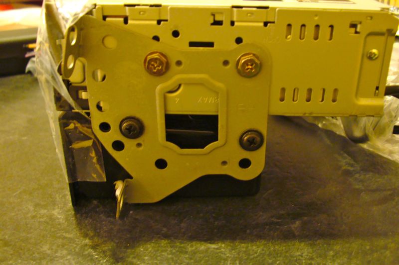 Yellow car stereo mounting bracket with screws and vents
