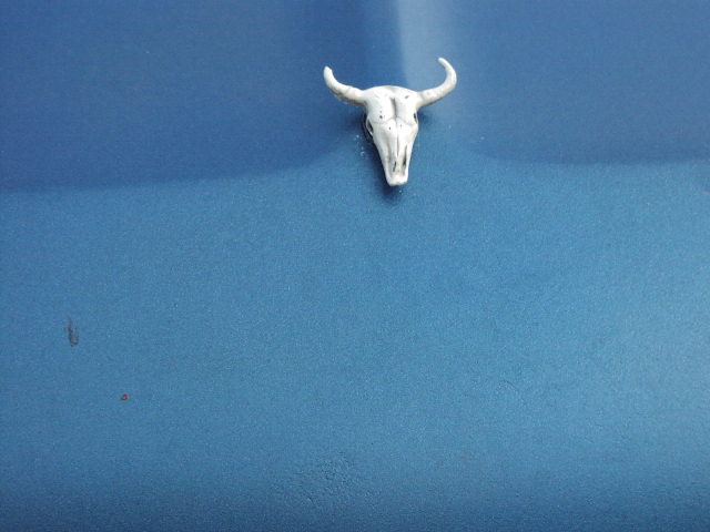 White bull skull emblem on a blue surface. Supermotors.net logo in lower right