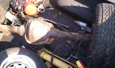 1990 Ford Bronco - Rear axle assembly and spare tire are in the truck bed with other items.