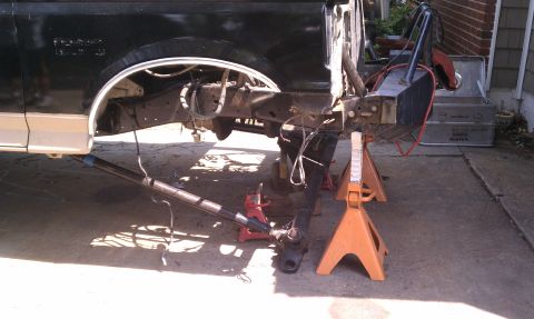 1990 Ford Bronco - The rear section of a 1990 Ford Bronco is supported by jack stands as it undergoes repairs.