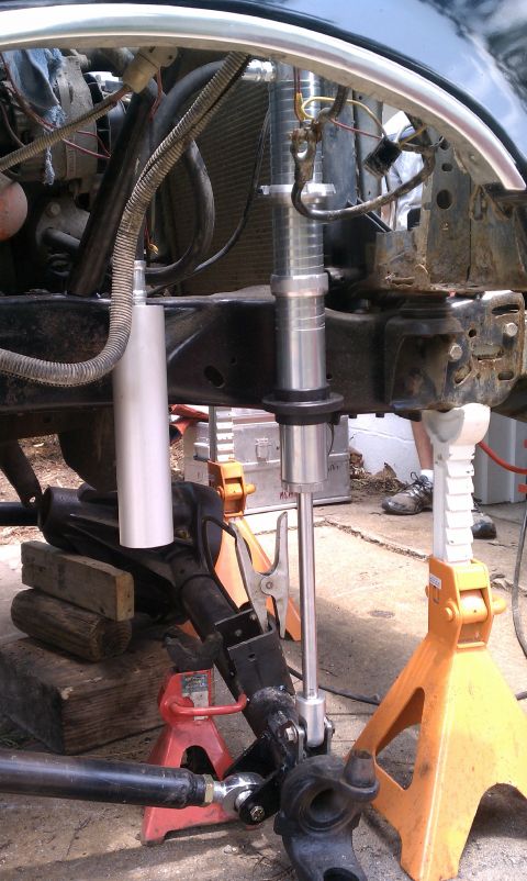 1990 Ford Bronco - Suspension work in progress on a vehicle, supported by jack stands.