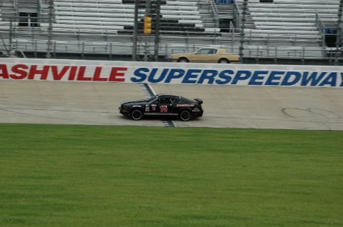 2007 Ford Mustang - A black race car with the number 15 is on the track at Nashville Superspeedway, with another car in the background.