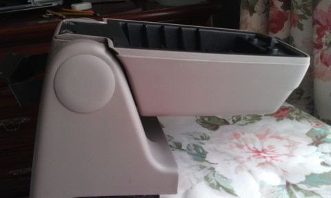 1991 Ford Mustang - This is a close-up view of a vehicle's center console armrest, showing its internal storage compartments.