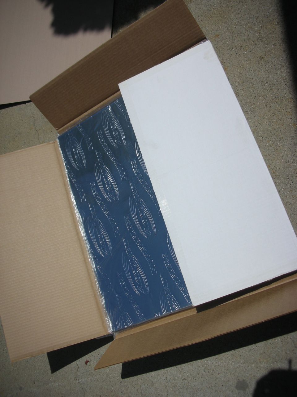 Blue sound deadening material with embossed pattern in cardboard box