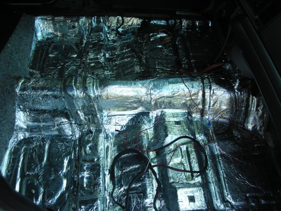 Car floor with sound deadening material and wires installed