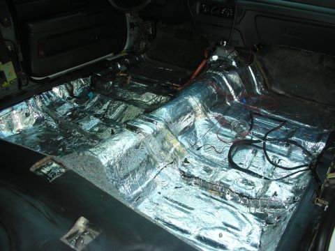 2004 Ford Crown Victoria - The interior of a 2004 Ford Crown Victoria is shown with sound deadening material applied to the floor and exposed wiring.