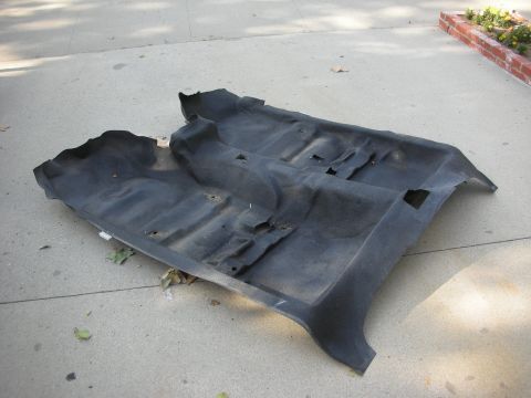 2004 Ford Crown Victoria - Car floor carpet removed from vehicle and placed on concrete outdoors.