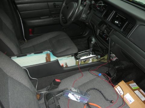 2004 Ford Crown Victoria - The center console of a 2004 Ford Crown Victoria is disassembled, revealing wiring and sound-deadening material.