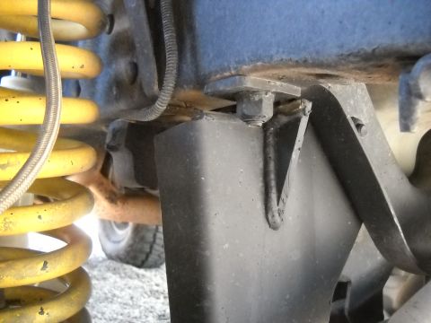 1986 Ford Bronco II - Detail shot of suspension components, including yellow coil springs and black metal brackets.