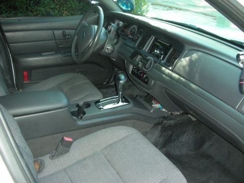2004 Ford Crown Victoria - The interior of a police vehicle is shown, the driver's side controls and passenger area.