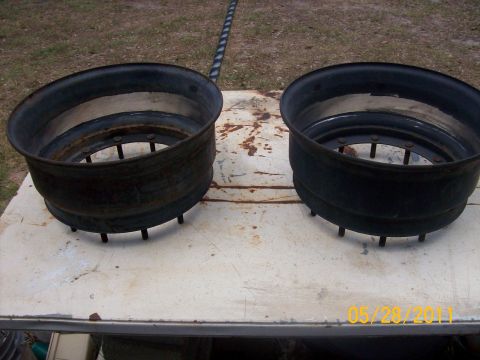 1982 Ford F-100 - Two old, rusty rims sit on a weathered table, with a date stamp visible in the corner.