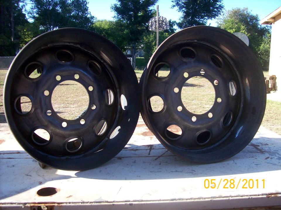 Two black truck wheels with multiple lug holes and large center bore