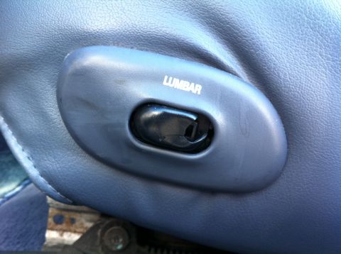 1999 Ford Crown Victoria - The interior of a vehicle shows a control for lumbar support on the seat.