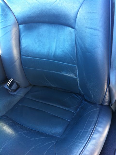 1999 Ford Crown Victoria - Close-up of a worn blue leather car seat interior.