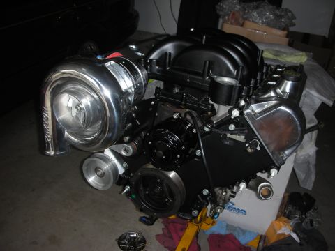 1992 Ford Crown Victoria - Engine assembly with a large turbocharger is displayed on a stand.