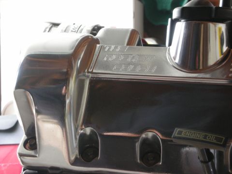 1992 Ford Crown Victoria - A close-up view of a polished chrome engine part with engraved text and an oil label.