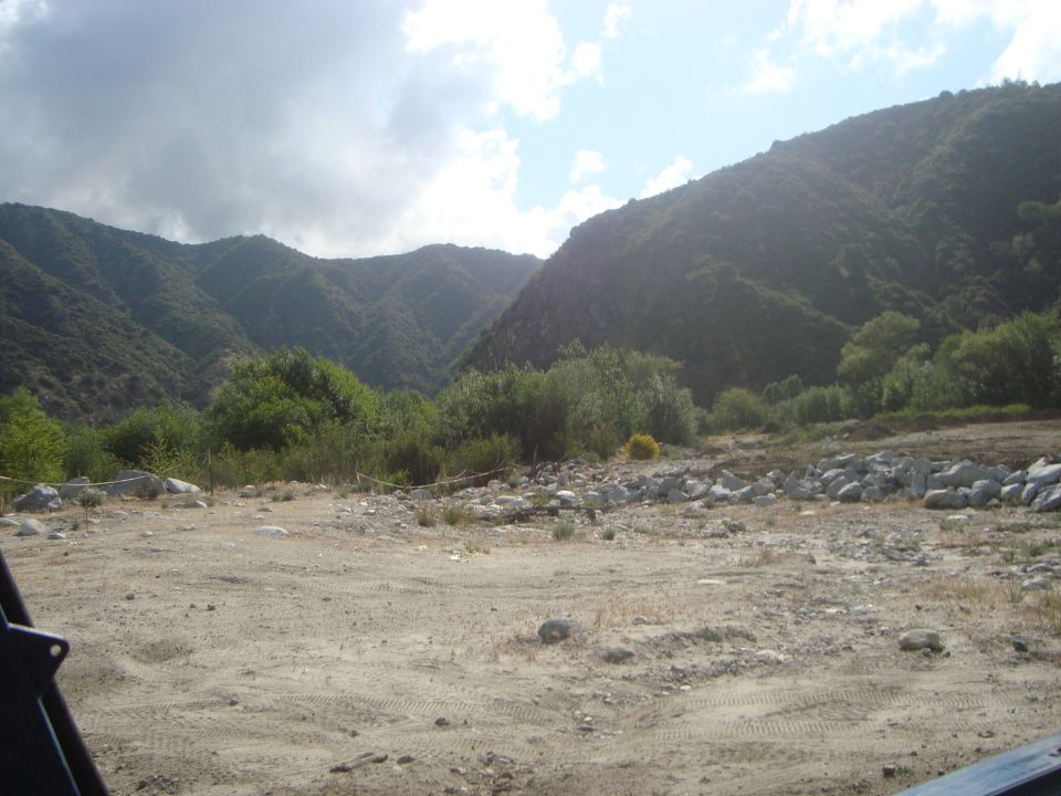 Dirt road in a mountainous area with trees and rocks