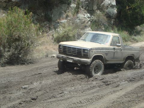 1986 Ford Bronco - This 1980s Ford Bronco navigates a muddy off-road trail.