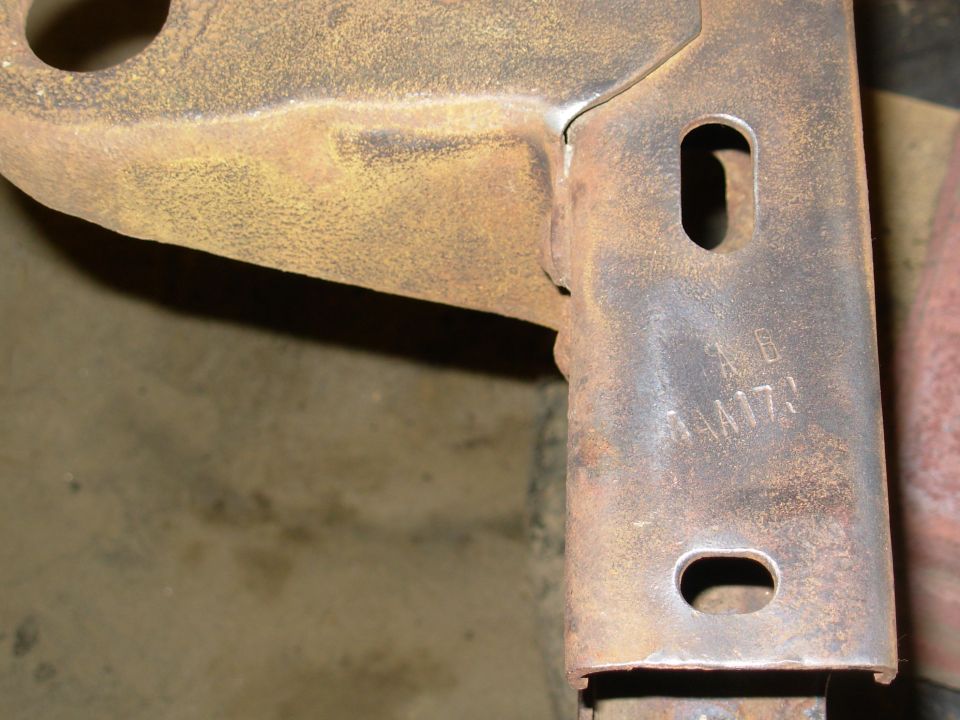 Rusty steel bracket with slotted holes and stamped markings