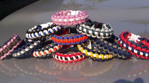 2006 Dodge Charger - A collection of colorful paracord bracelets are displayed on a reflective surface, possibly a car's hood.