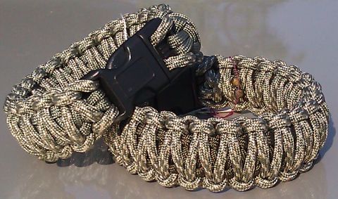 2006 Dodge Charger - Close-up of two camouflage paracord survival bracelets with black plastic buckles.