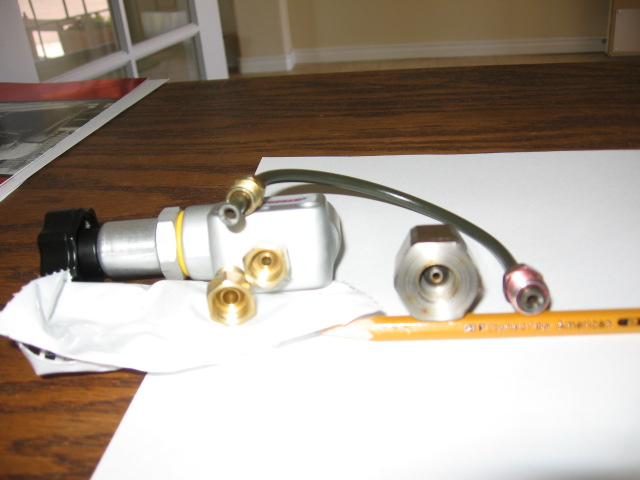 Brake proportioning valve with brass fittings and short hard line on a wood table