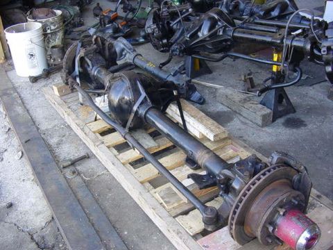 1992 Ford Bronco - Multiple vehicle axle assemblies are visible in this workshop setting.