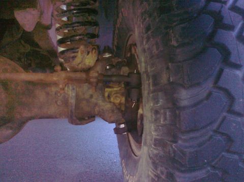 1995 Ford Bronco - Detail of a vehicle's suspension system and off-road tire, showing significant wear and tear.