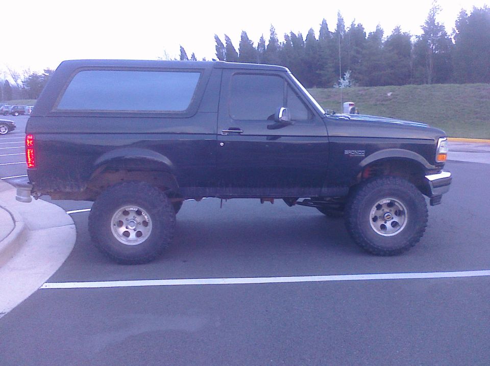 Black 1995 Ford Bronco parked in a lot, lifted with off-road tires