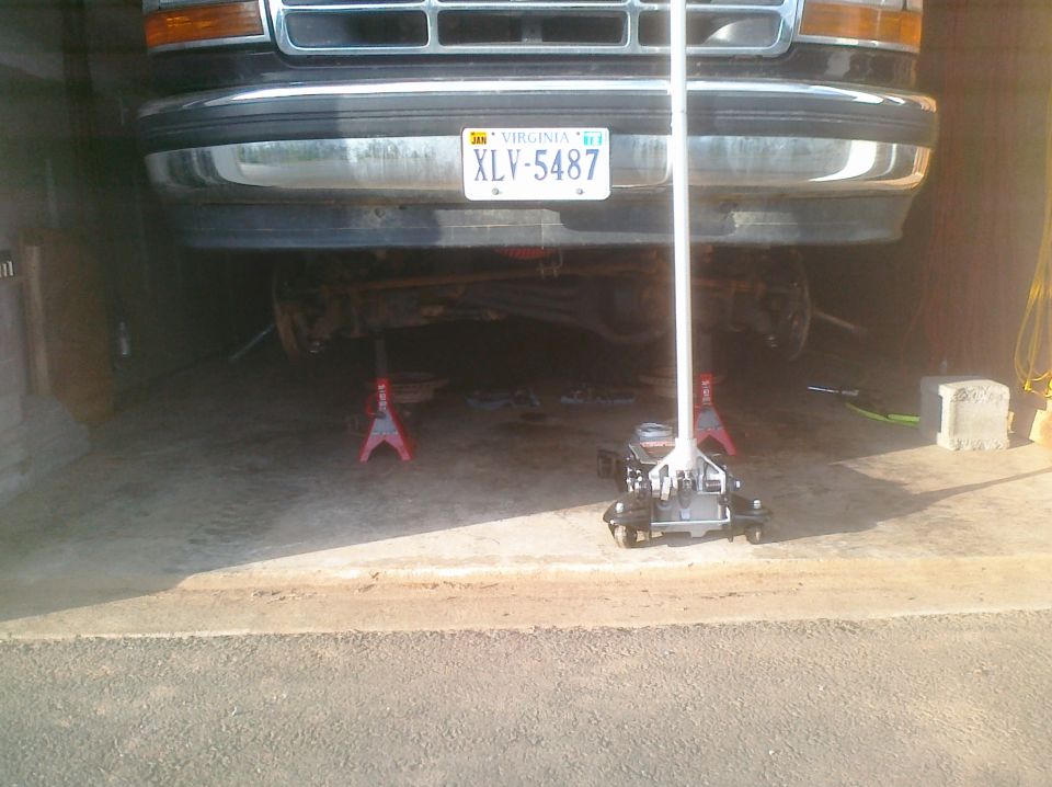 1995 Ford Bronco front end lifted on jack stands, showing grille and Virginia license plate XLV-5487