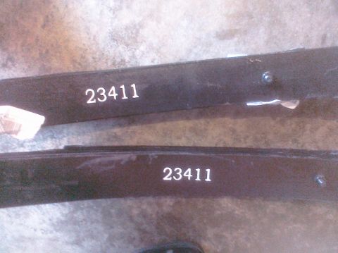 1995 Ford Bronco - Close-up view of two automotive leaf springs, each marked with the number 23411.