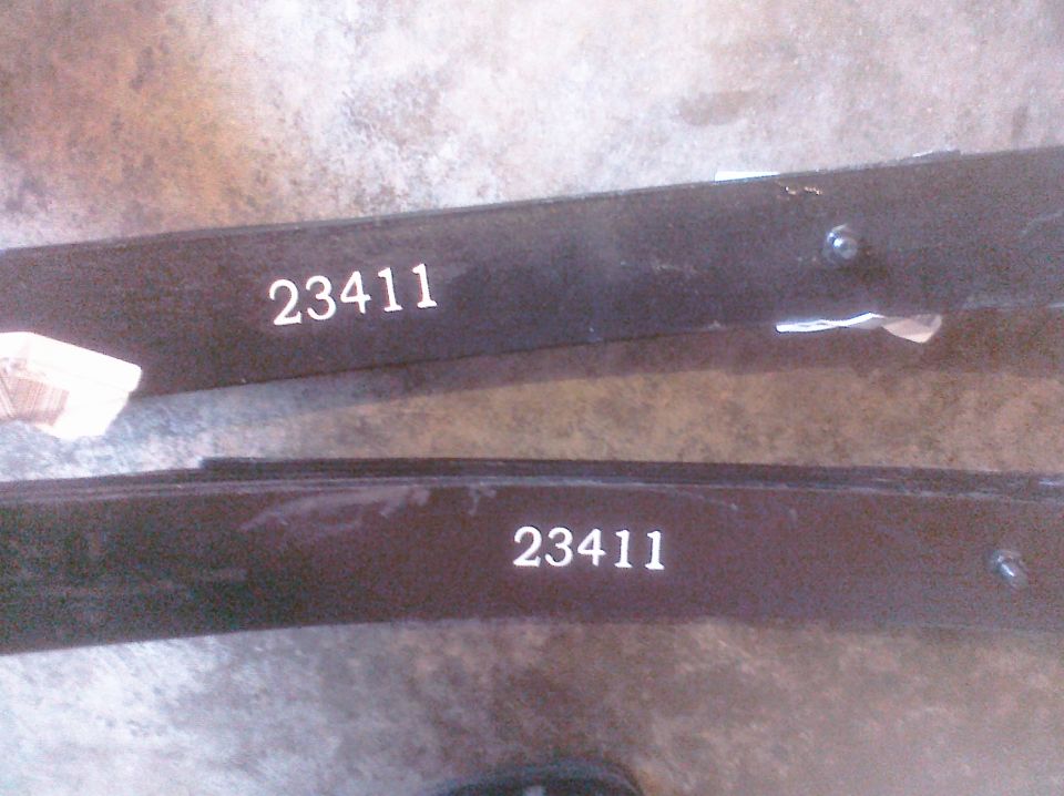 Two black leaf springs with white numbers '23411' stamped on them
