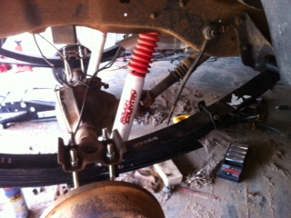 1995 Ford Bronco - Close-up view of vehicle rear suspension components, including a shock absorber and leaf springs.