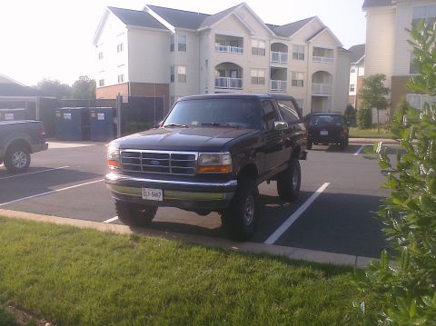 1995 Ford Bronco - A black 1995 Ford Bronco is parked in a lot with another vehicle visible in the background.