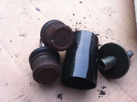 2007 Subaru Impreza - Two rusty ball joints and a black metal cylinder with a threaded bolt are laid out on a textured surface.