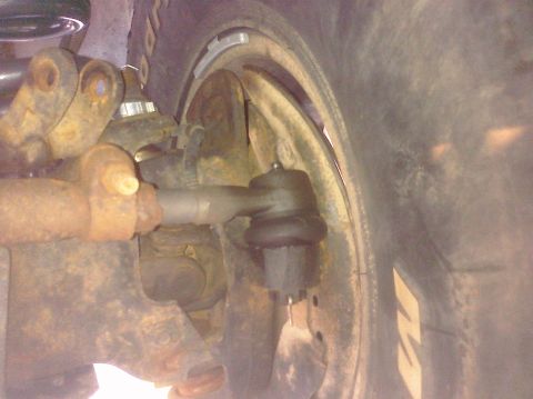1995 Ford Bronco - A close-up view of a vehicle's suspension system, showing rusty metal components and a tire.