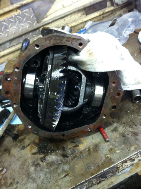 1993 Ford Bronco - Differential housing with internal gears exposed, resting on a workbench surface.