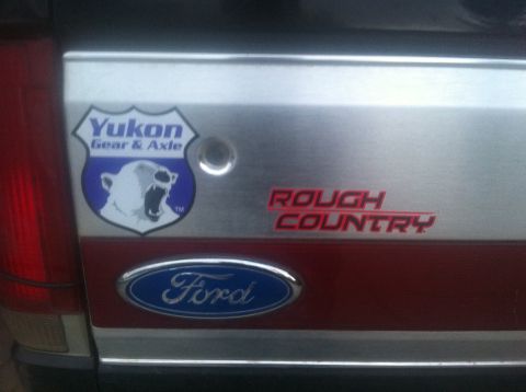 1990 Ford Bronco - Close-up of a Ford tailgate "Yukon Gear & Axle" and "Rough Country" decals.