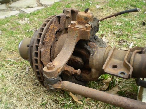 1979 Ford Bronco - This is a rusted front axle assembly with brake rotor and suspension components.