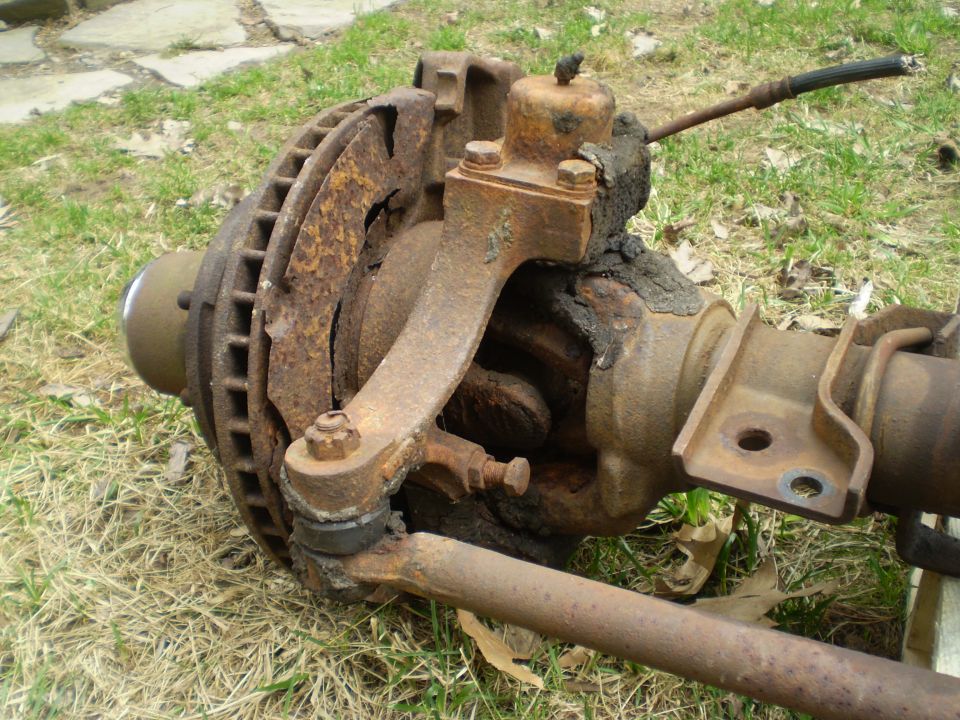 Rusted front axle assembly with brake rotor and suspension components