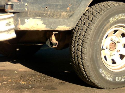1982 Ford Bronco - Close-up view of the rear tire and fender area of a vehicle, showing some rust on the body panel.