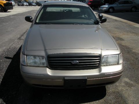 2001 Ford Crown Victoria - Front view of a tan 2001 Ford Crown Victoria, with a black grille and clear headlights.