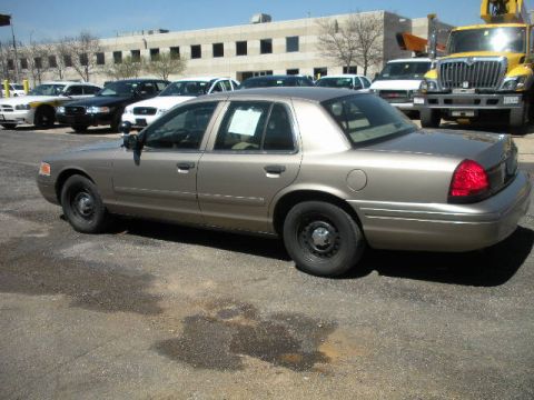 2001 Ford Crown Victoria - This 2001 Ford Crown Victoria is seen in a parking lot with other vehicles and a large building in the background.