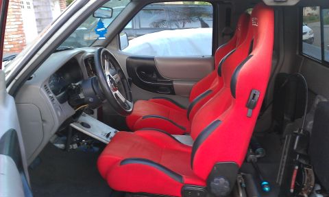1992 Ford Ranger - The interior of a 1992 Ford Ranger shows off its red racing seats and custom steering wheel.