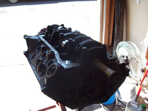 1985 Ford Bronco - Engine block and crankshaft assembly on a stand, with a fan in the background.