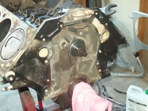 1985 Ford Bronco - Close-up of an engine block undergoing repair, with tools and a fan visible in the background.