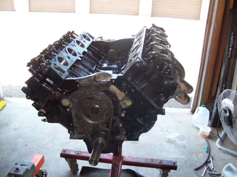 Engine block on a red stand, with timing chain and gears visible