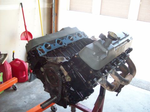 1985 Ford Bronco - Engine on an orange stand in a garage, ready for rebuild.